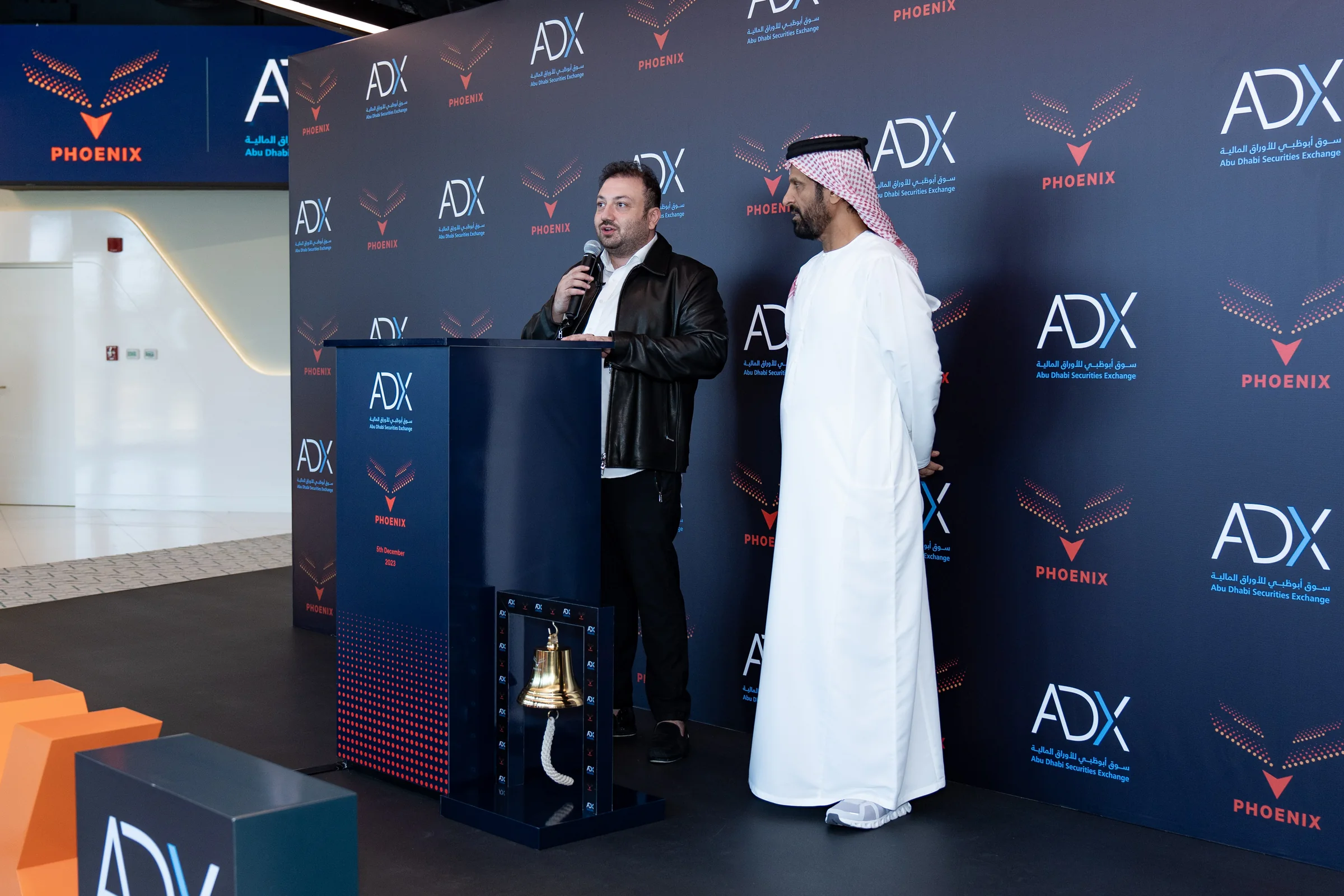 Phoenix Group opening address at the Abu Dhabi Securities Exchange podium beside the ceremonial bell