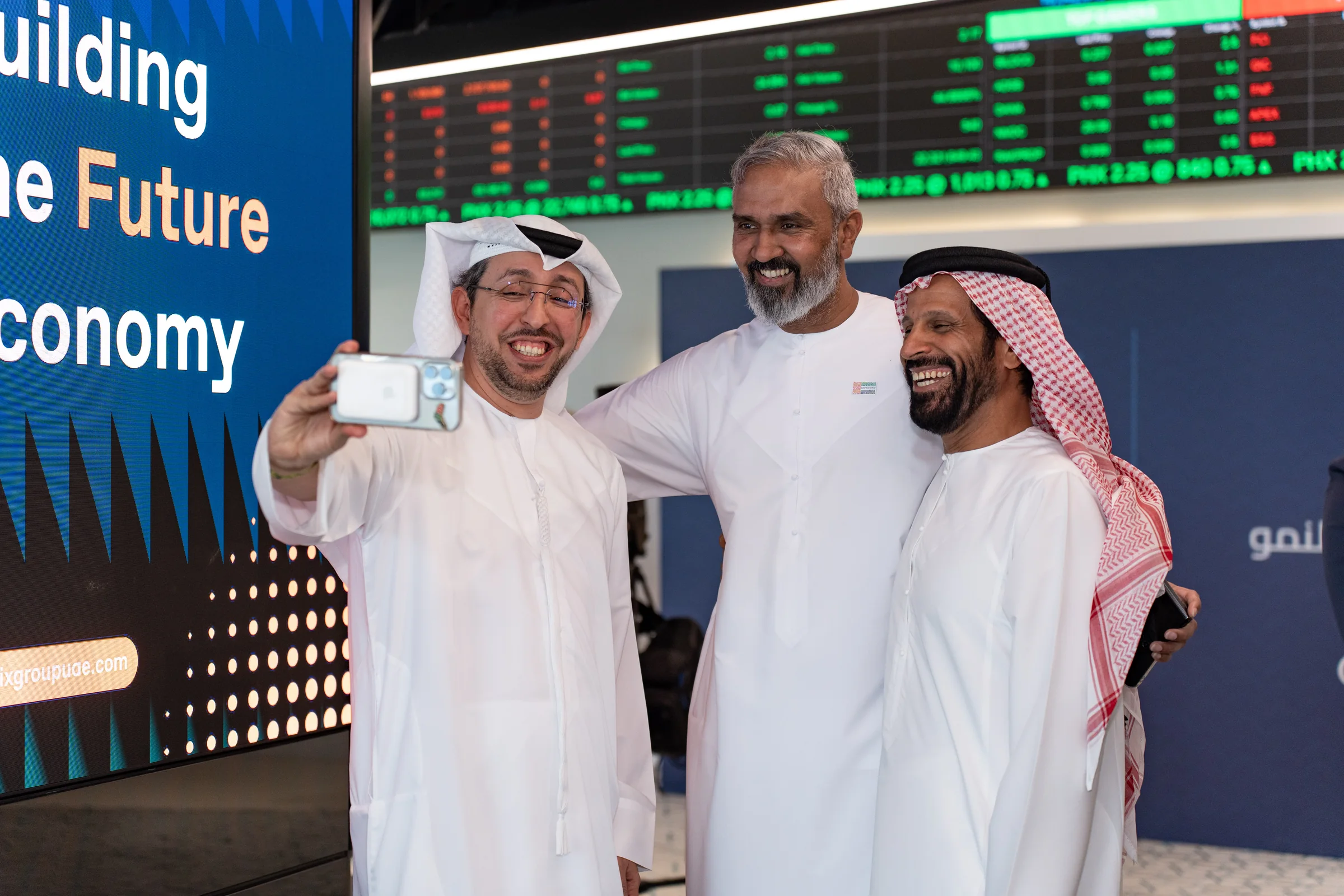 PHX trading on the Abu Dhabi Securities Exchange board on the first day, beside the Building the Future Economy campaign screen