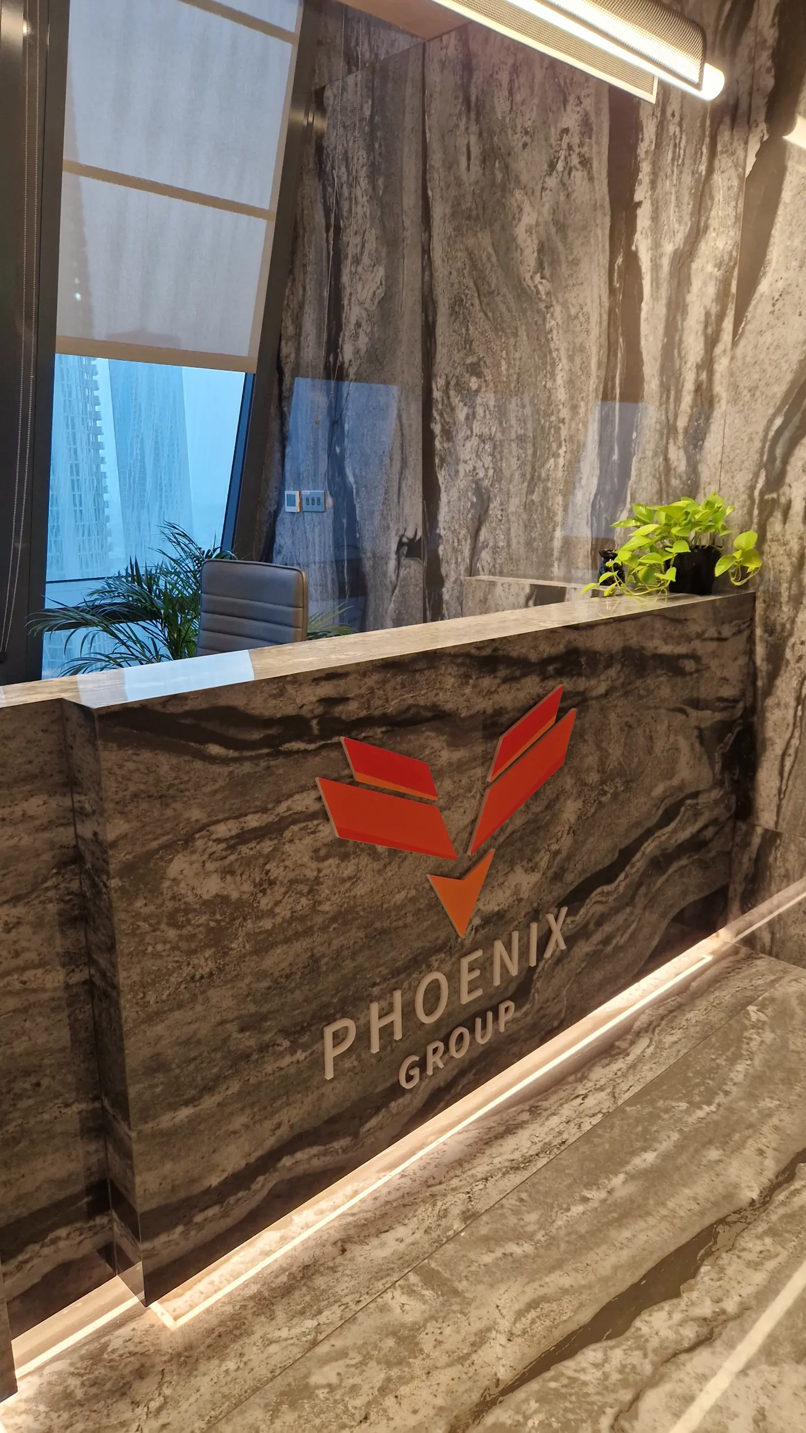 The Phoenix Group mark cut into the marble reception desk at the Dubai office