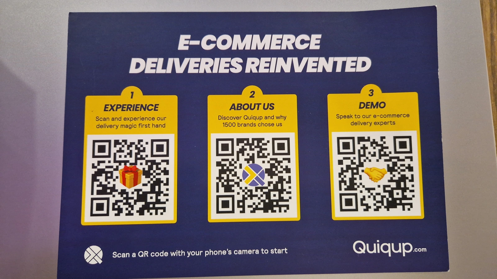 The printed Quiqup ABM postcard headed E-Commerce Deliveries Reinvented, carrying three numbered QR codes: Experience, About Us and Demo